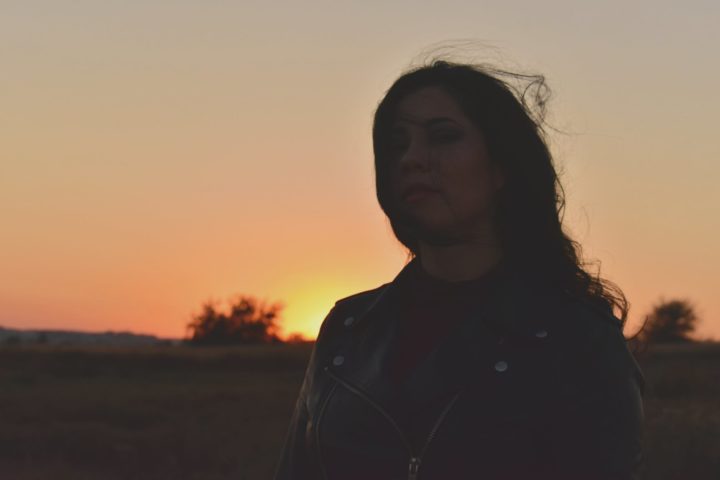 https://www.pexels.com/photo/woman-wearing-black-leather-zip-up-jacket-standing-on-field-during-golden-hour-1491033/