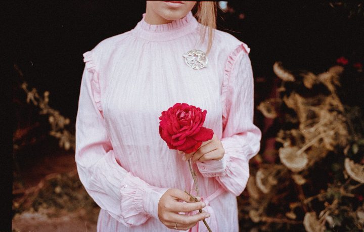 https://www.pexels.com/photo/shallow-focus-photo-of-person-in-pink-long-sleeved-shirt-holding-red-flower-3142506/