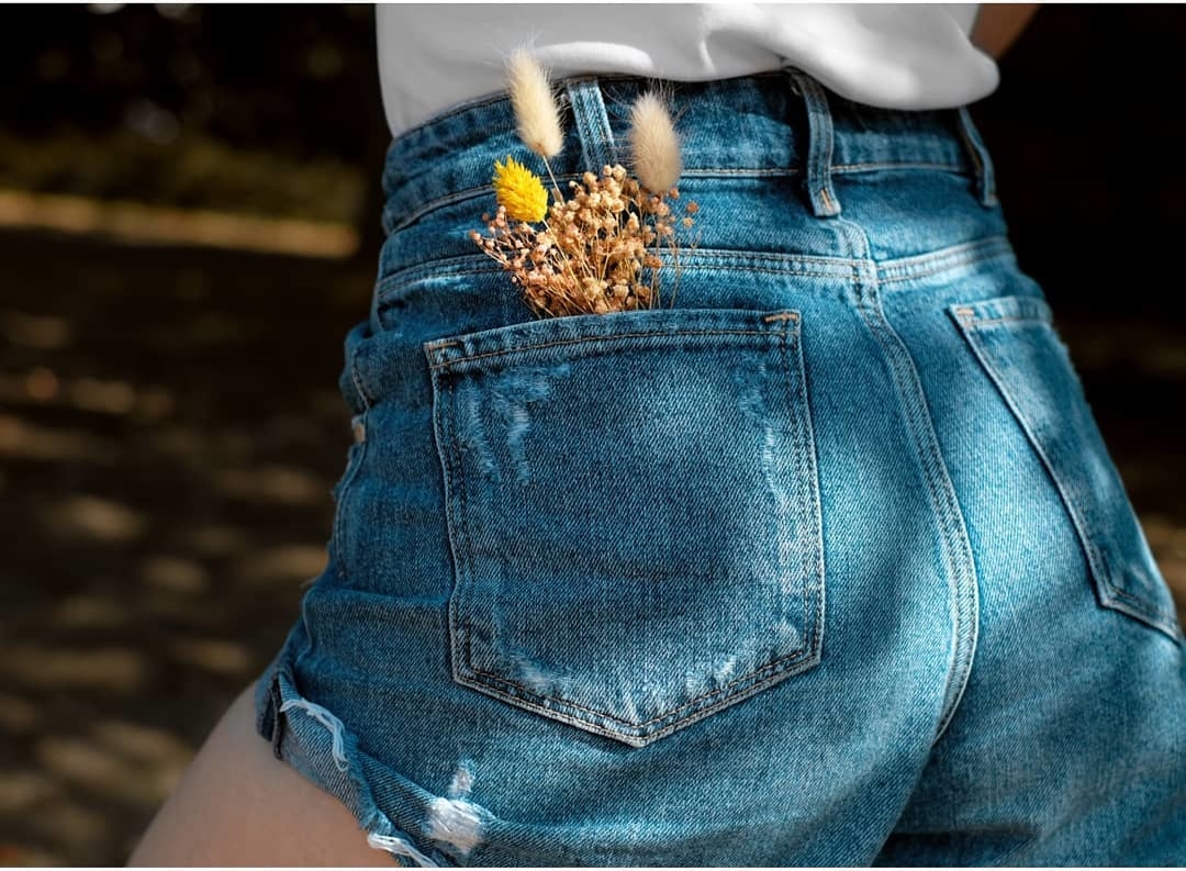 Frau in Jeans mit Trockenblumen