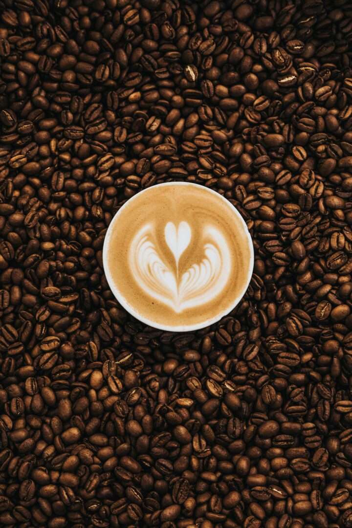 Eine Tasse Kaffee umgeben von Kaffeebohnen