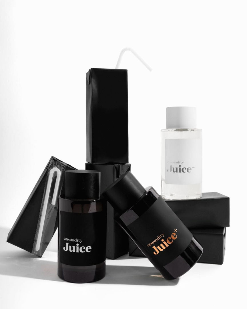 Alle drei Varianten von Commodity Juice Parfum – Personal im weißen Flakon, Expressive im schwarzen Flakon mit weißer Schrift und Bold im schwarzen Flakon mit bronzefarbener Schrift