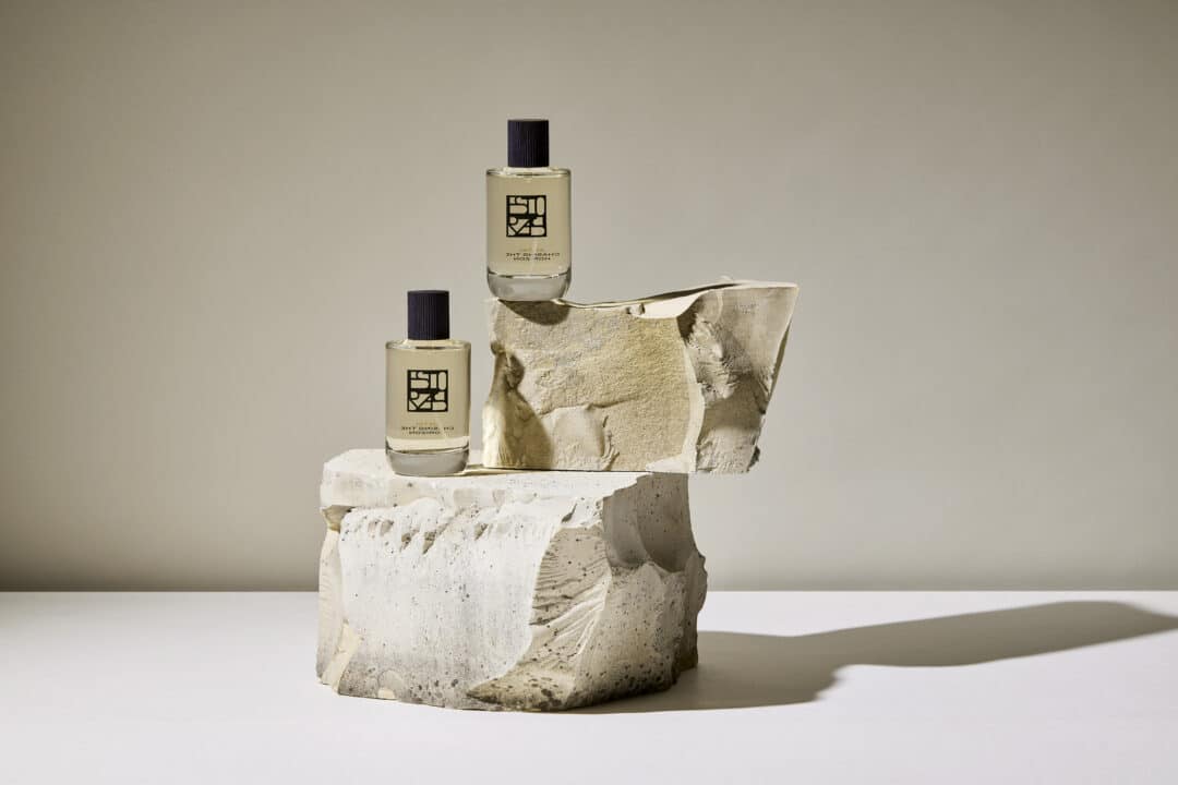 Two bottles of Antal perfume by Estoras, minimalistically staged on light-colored natural stones against a neutral background - a symbol of clarity and strength