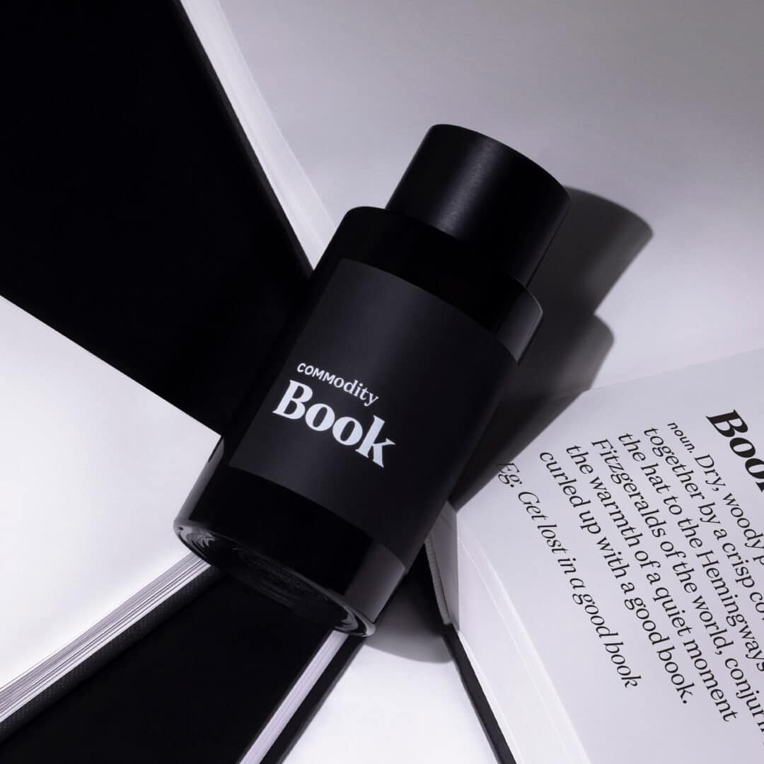Commodity Book Parfum Expressive – schwarzer Flakon auf geöffnetem Buch, elegante Alltagsvariante