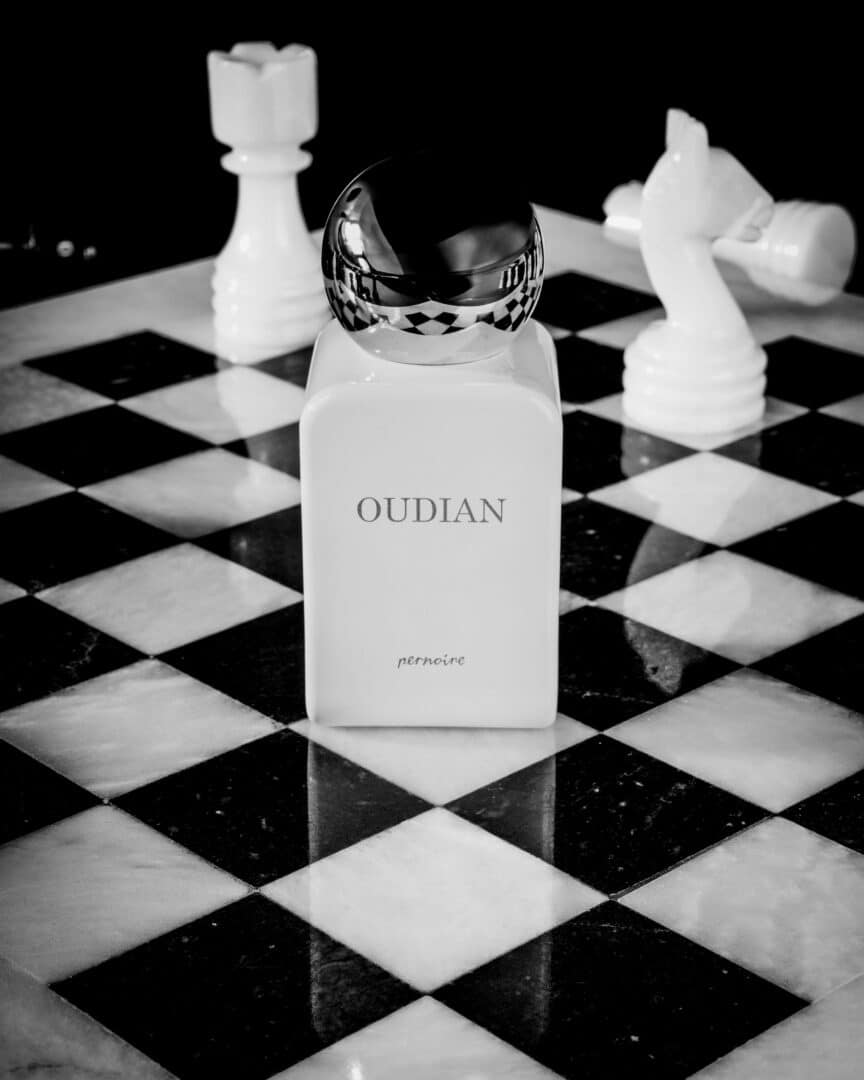 Oudian von pernoire – Duftflakon auf Schachbrett mit weißen Figuren, Symbol für Macht und Dominanz