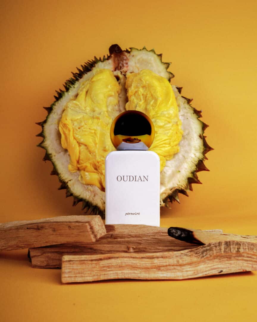 Oudian von pernoire – Nischenduft mit Oud und Durian, Flakon vor aufgeschnittener Durianfrucht