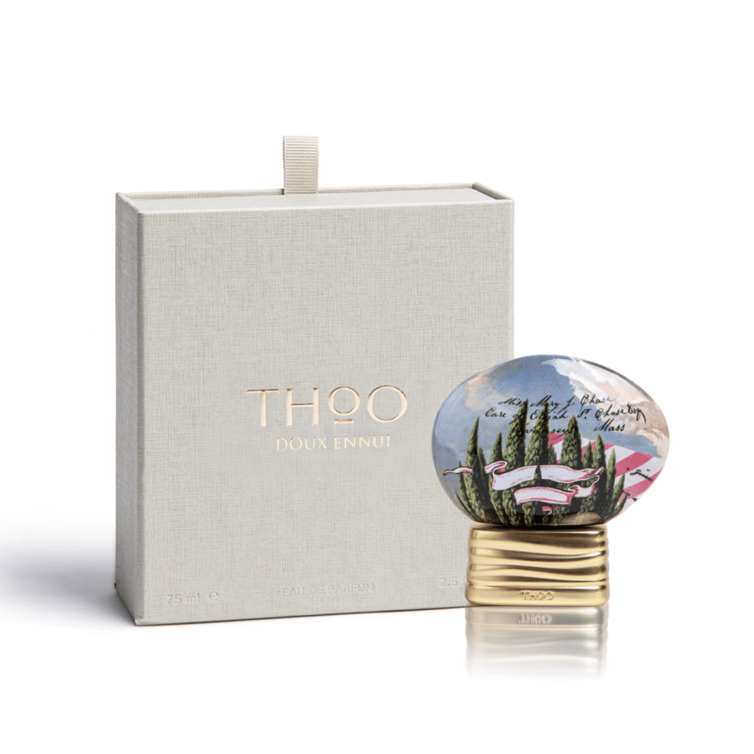 Product photo of Doux Ennui by THoO: the oval, illustrated bottle stands in front of a structured, light-colored box with a gold-embossed logo. The photo shows the packaging and design of the eau de parfum in a clear, minimalist style.