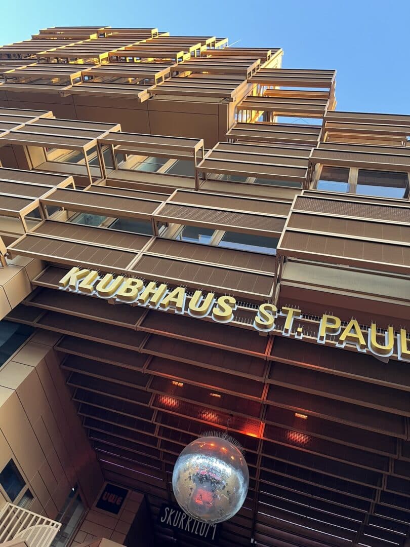 Fassade des Klubhaus St. Pauli in Hamburg mit Spiegelkugel am Eingang bei Abendlicht.