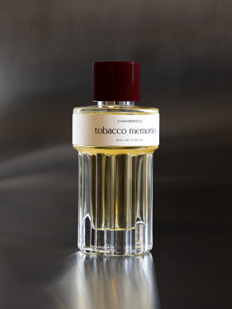 Flakon von Tobacco Memories von Chambre52 auf dunklem, reflektierendem Hintergrund.