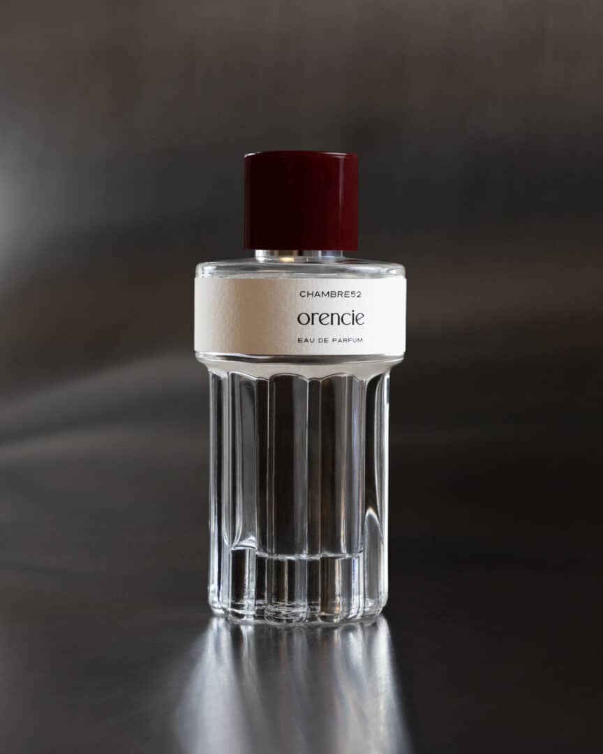 Flakon von Orencie von Chambre52 auf dunklem, leicht reflektierendem Untergrund.