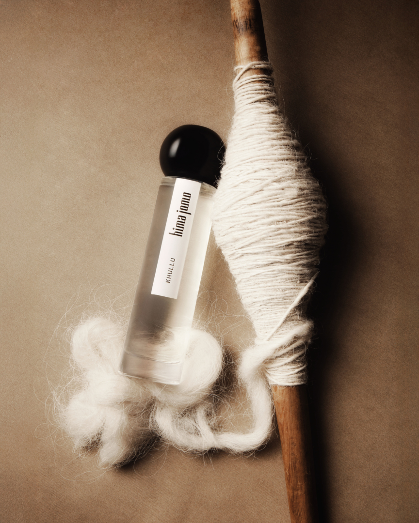 Khullu by Hima Jomo Eau de Parfum with yak wool and wooden spindle on a warm background