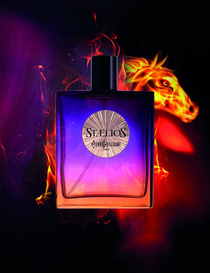 Stælios von Pierre Guillaume – leuchtende Wärme und dynamische Intensität Stælios von Pierre Guillaume Paris – Parfumflakon in violett-orangem Farbverlauf vor dunklem Hintergrund mit flammenartiger Lichtinszenierung