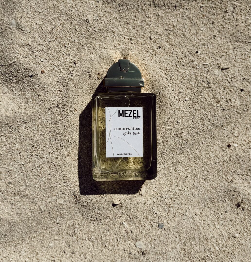 Cuir de Pastèque - Summer fragrance by Mezel Paris Cuir de Pastèque by Mezel Paris Eau de Parfum on sandy ground in the sunlight