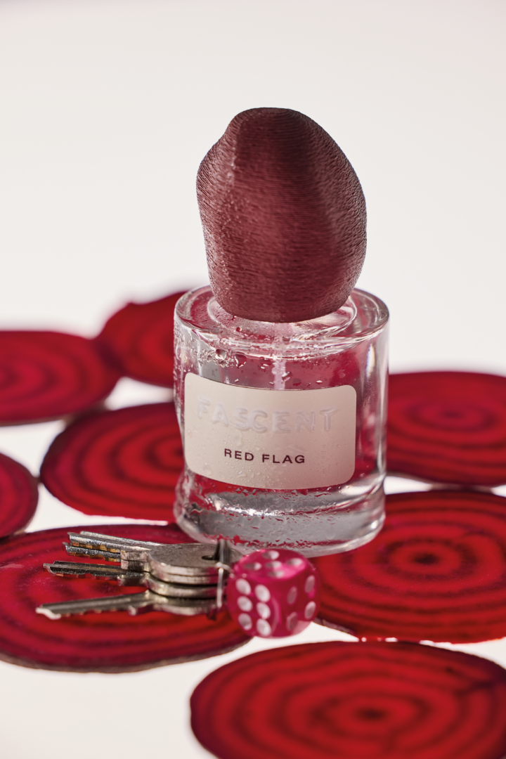 Red Flag von Fascent – würzig-holziger Duft mit Rote-Bete-Akkord Fascent Red Flag Eau de Parfum Flakon mit roter Kappe auf Rote-Bete-Scheiben, davor Schlüsselbund und roter Würfel